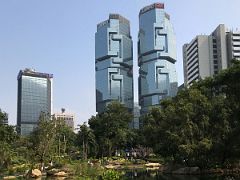 02B Artificial lake surrounded by trees with the twin towers of the Lippo Centre towering overhead in Hong Kong Park